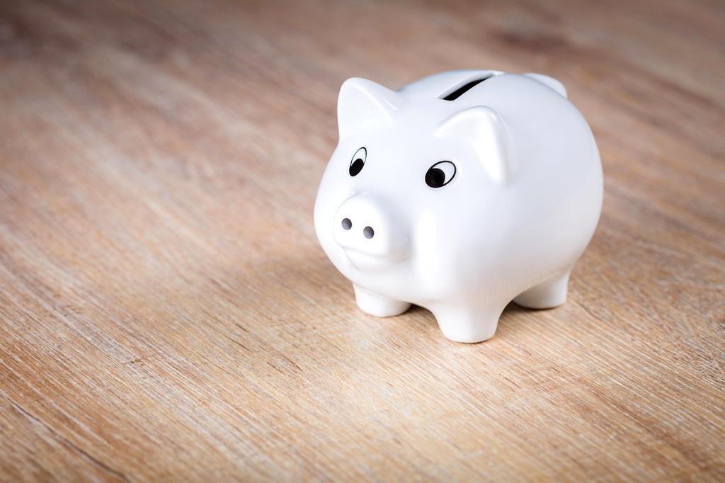 Piggy bank next to coins on a table